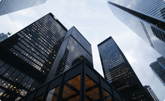 city-buildings-day-business A group of tall buildings with windows and glass.